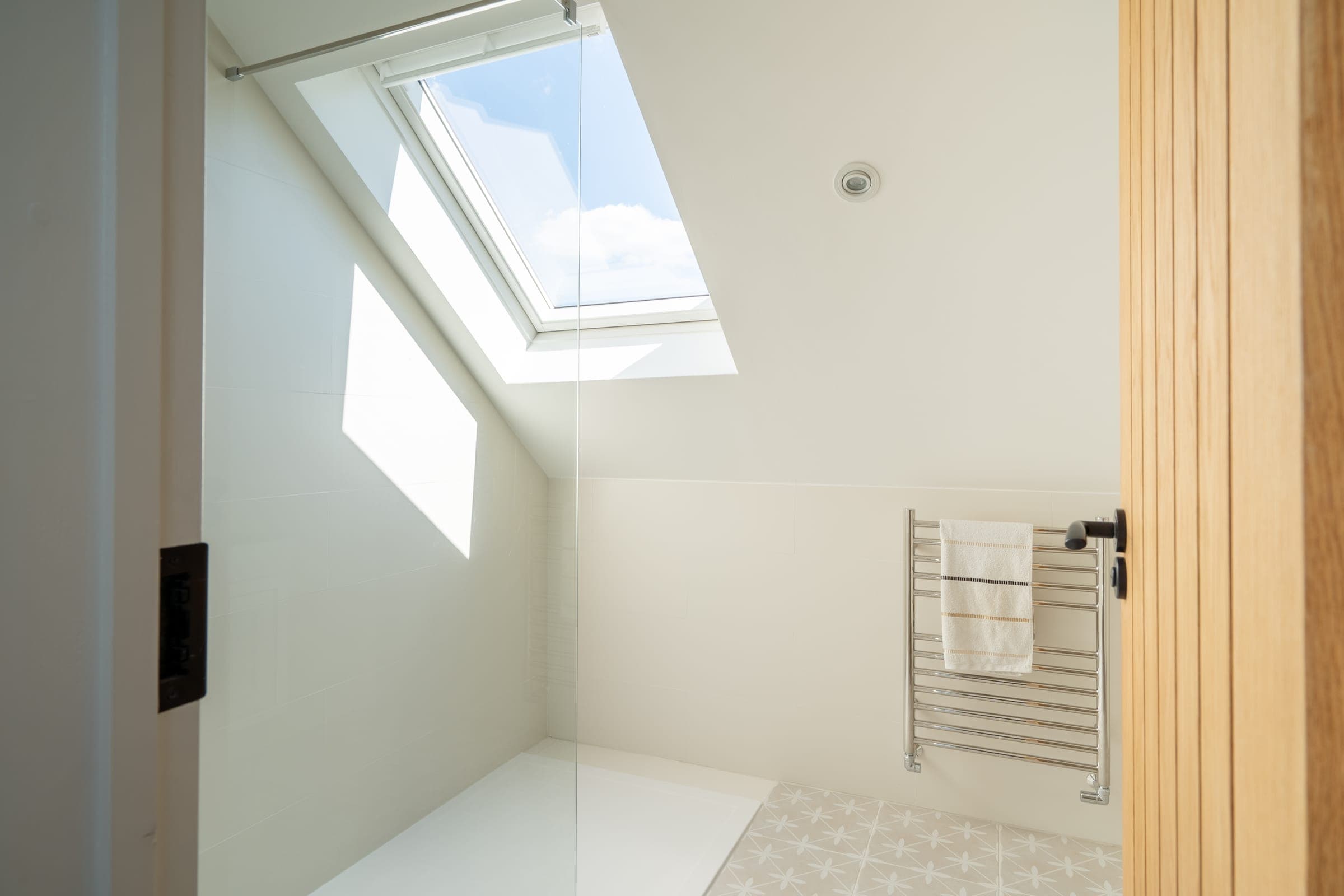 Loft en-suite with velux rooflight, walk-in shower and geometric floor tile, Chorleywood.