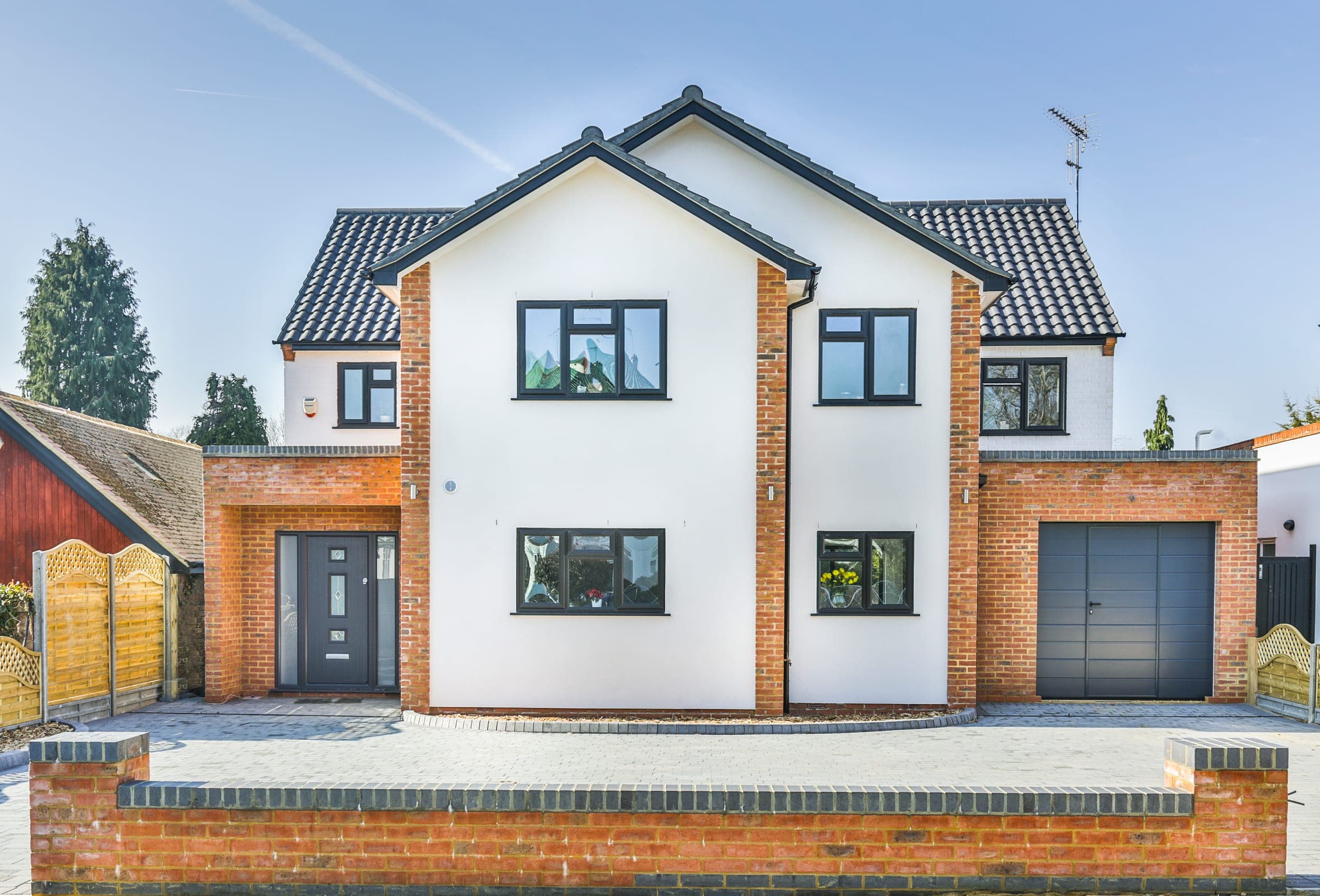Contemporary new-build family home, Pinner. White render and red brick.