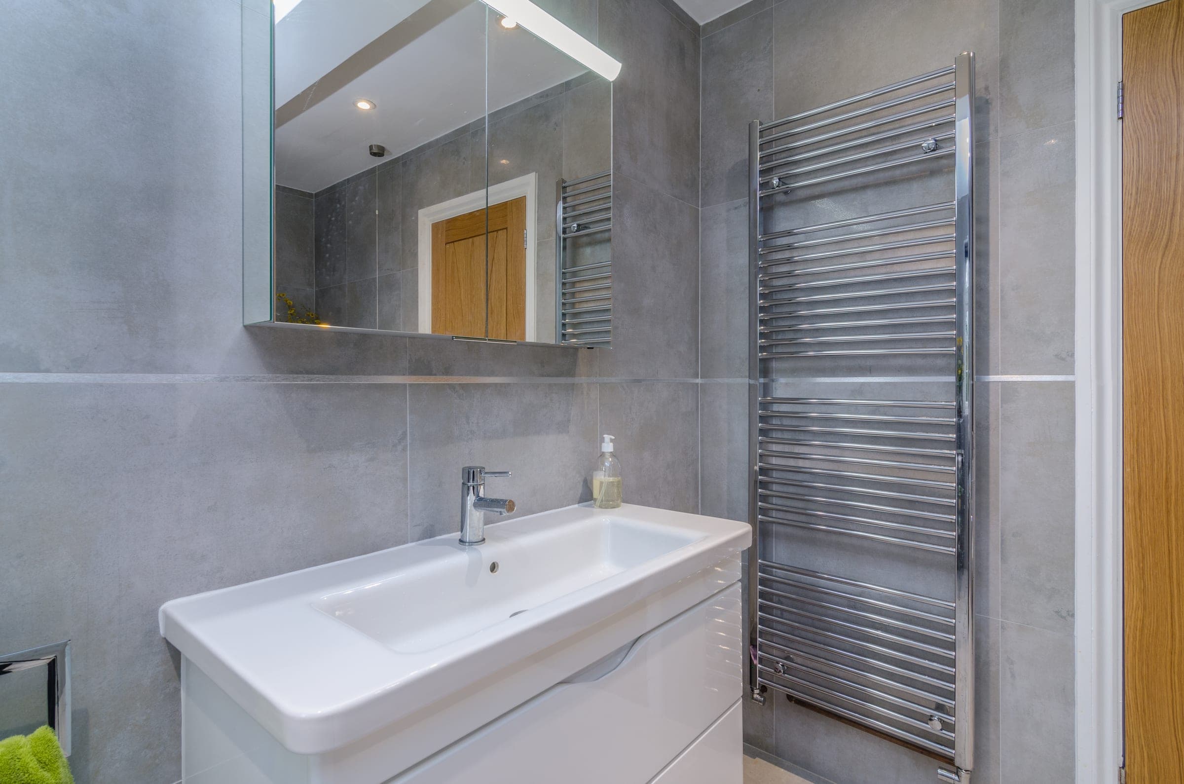 Guest bathroom. Grey tile with chrome heated rail